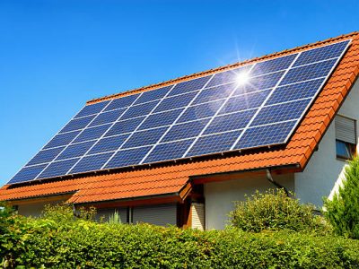 Solar panel on a red roof reflecting the sun and the cloudless blue sky Solar panel on a red roof reflecting the sun and the cloudless blue sky